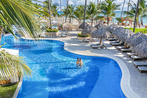 Majestic Mirage Resort a bright blue pool near a tropical beach front