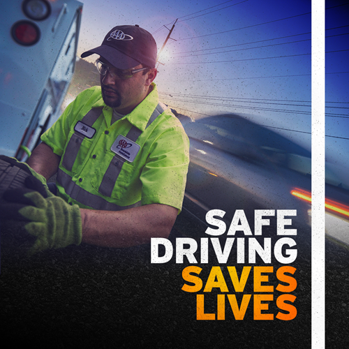 AAA roadside responder performing car repairs beside highway