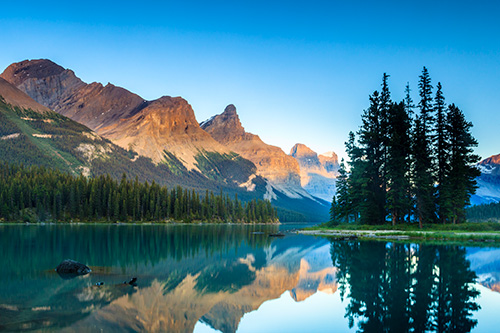 the Rocky Mountains behind a clear reflective lake
