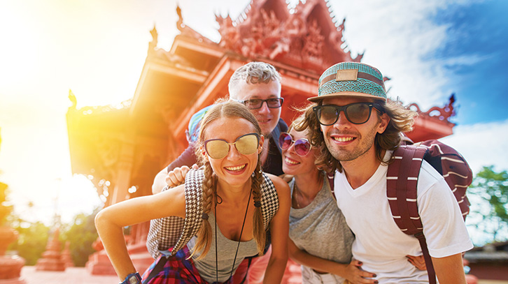 group of teens pose in front of a temple