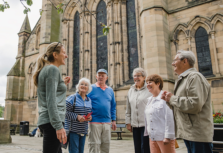 group on a tour in front of gothic building