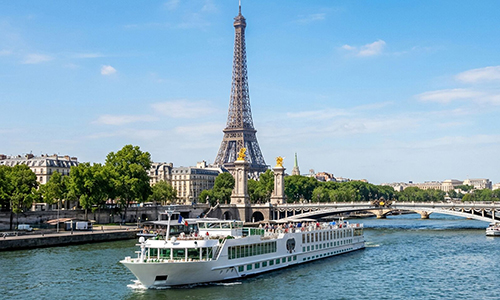 a river cruise passes in front of the Eiffel Tower