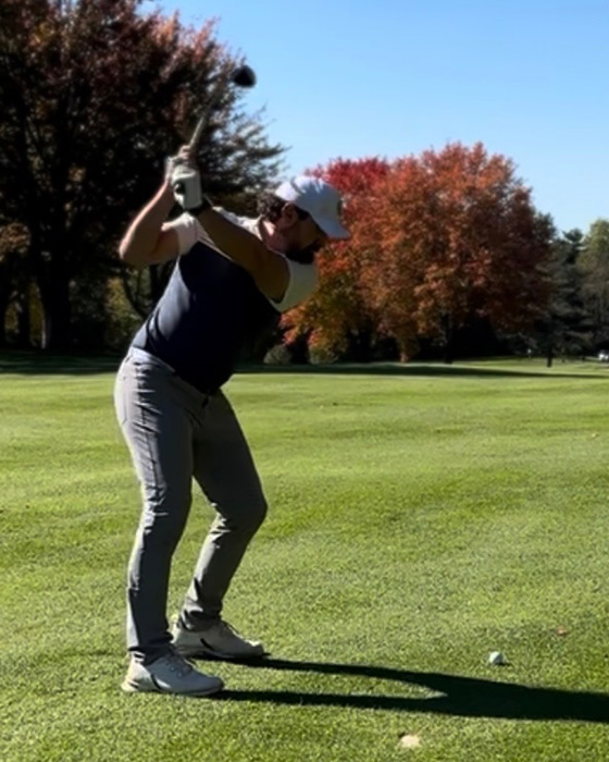 golf player about to hit a golf ball